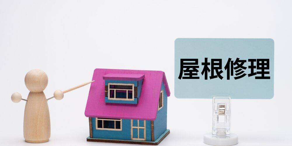 木の人形が指揮棒でモデルハウスの屋根を指し示し、その横に水色のパネルに黒文字で『屋根修理』と書かれた立て札が置かれたイメージ