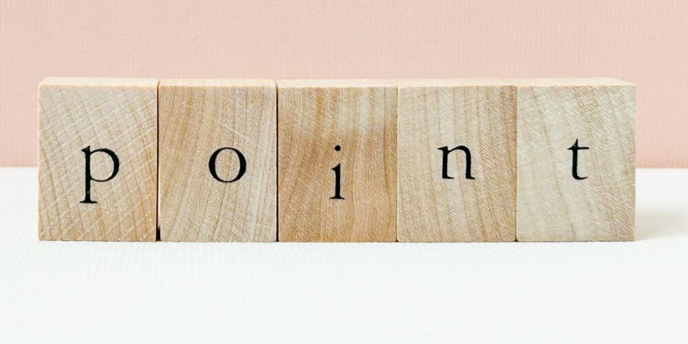 白とピンクの背景上に並べられた木製ブロックに「point」と書かれたデザイン。ポイント解説用の素材