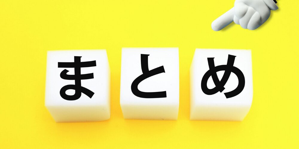 黄色い背景の上に白い立方体ブロックが3つ並べられ、それぞれに黒文字で『ま』『と』『め』と書かれている。その上に手のアイコンが指し示しているイメージ