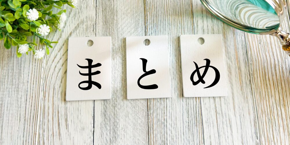 木目調のテーブル上に白い札が3枚並べられ、それぞれにひらがなで「ま」「と」「め」と書かれている写真